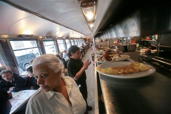 Waiters Elba Aquino, foreground, and Alex Nunez, right, have worked at the diner for more than 14 years.